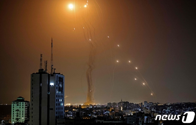 (가자 AFP=뉴스1) 우동명 기자 = 11일(현지시간) 팔레스타인 자치 지역인 가자지구 상공에서 무장 정파 하마스가 쏜 로켓포를 이스라엘 방공시스템 아이언돔의 미사일이 요격을 하고 있다.   (C) AFP=뉴스1  
