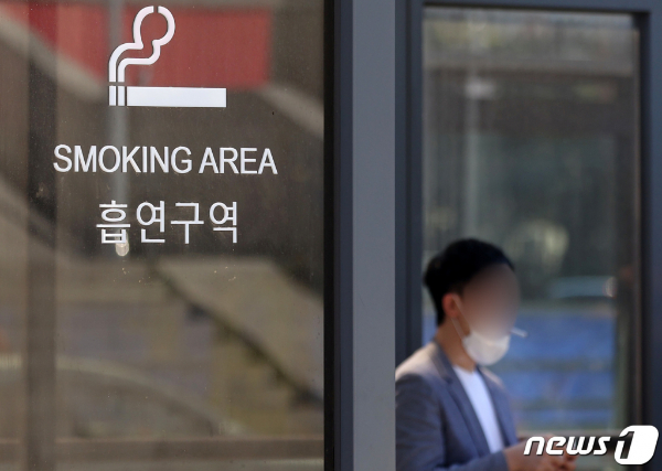 (서울=뉴스1) 조태형 기자 = 서울역 광장 흡연구역에서 한 흡연자가 마스크를 내린 채 흡연하고 있다.  /뉴스1  