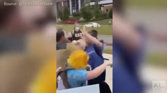  한 여학생이 미국 알라바마 대학 버밍햄 캠퍼스에서 여성 혐오적 발언이 적힌 팻말을 든 채 시위하는 남성을 주먹으로 때리고 넘어뜨려 제압했다. /사진=AL.com 유튜브 캡처