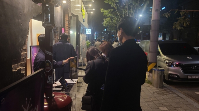  지난 22일 오후 서울 성수동 패션 편집숍 수피에 마련된 팝업스토어 '금성오락실' 입구 모습. 사람들이 내부로 입장하기 위해 발열체크와 설문조사를 작성하고 있다./사진=오문영 기자