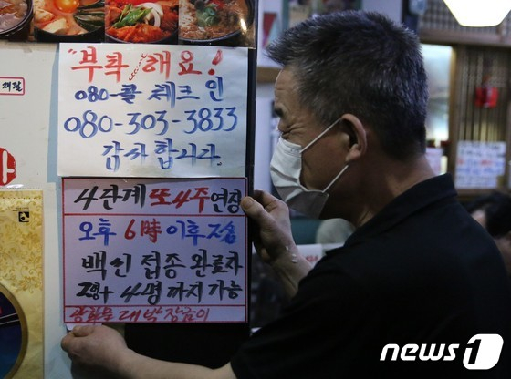 9월 24일 서울 광화문의 한 음식점에서 관계자가 백신 인센티브 관련 문구가 적힌 안내문을 붙이고 있다. /사진 = 뉴스1