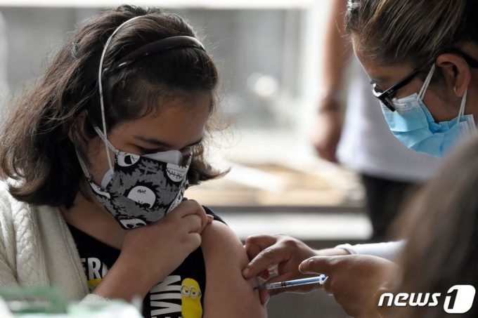 (멕시코 시티 AFP=뉴스1) 우동명 기자 = 25일 (현지시간) 멕시코 시티에 마련된 코로나19 백신 접종소에서 청소년이 화이자 백신을 맞고 있다.  (C) AFP=뉴스1  