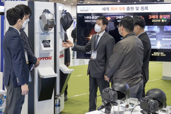 서울 코엑스에서 26일부터 29일까지 열리는 '2021 스마트비즈엑스포'에 참가한 안면보호구 생산기업 '오토스윙' 허문영 대표(가운데)가 삼성전자 관계자들과 개발중인 제품에 대해 협의하고 있다./사진제공=삼성전자