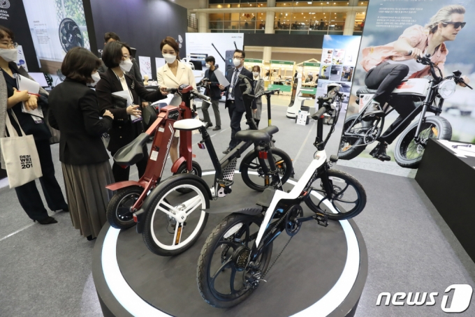 지난 18일 대구 엑스코(EXCO)에서 개막한 '디자인위크 인 대구 2021' 전시장을 찾은 관람객들이 간편한 접이식 자전거를 살펴보고 있다. /사진=뉴스1