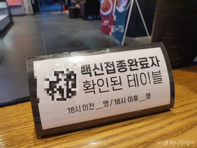 13일 서울 광진구의 한 카페에 '백신 접종을 완료했다'는 내용의 팻말이 놓여 있다. / 사진 = 오진영 기자 