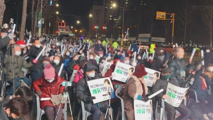 24일 오후 6시 서울 강남구 삼성서울병원 정문 앞에 모인 우리공화당 당원들이 박근혜 전 대통령을 응원하는 글귀가 적힌 포스터를 들고 앉아있다. /사진=홍효진 기자