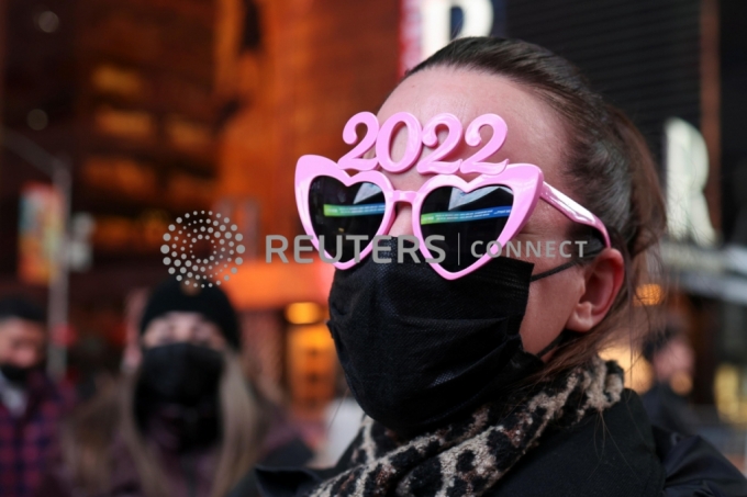 A person wears 2022 glasses ahead of New Year's Eve celebrations in Times Square as the Omicron coronavirus variant continues to spread, in the Manhattan borough of New York City, U.S., December 31, 2021. REUTERS/Hannah Beier