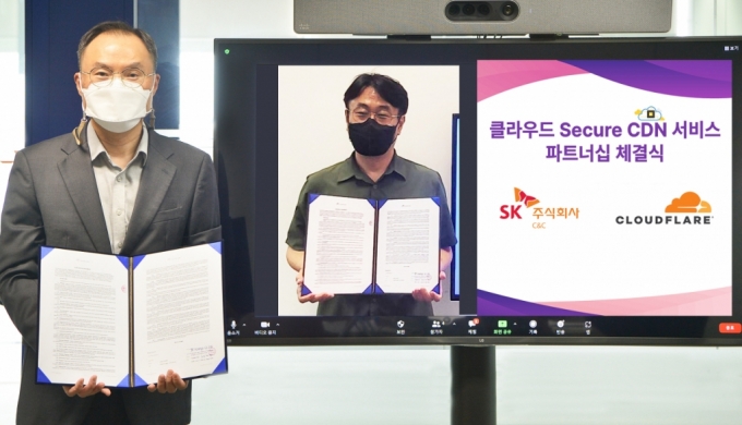 파트너십 체결 후 SK(주) C&C 신현석 Cloud Transformation그룹장(왼쪽)과 클라우드플레어 한병용 한국대표가 기념 촬영을 하는 모습./사진제공=SK C&C