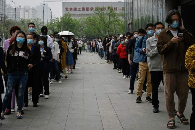 25일 (현지시간) 코로나19 봉쇄 조치가 사실상 내려진 중국 베이징에서 주민들이 면봉 검사를 받기 위해 길게 줄을 서 있다.  /AFP=뉴스1  