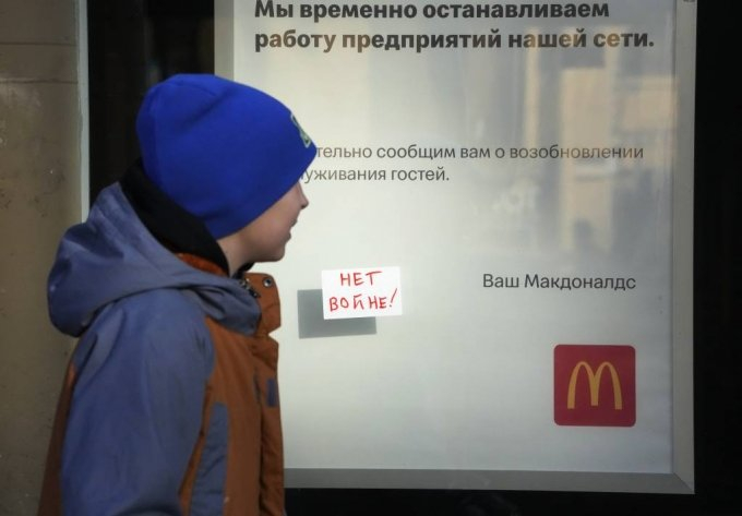 [상트페테르부르크=AP/뉴시스] 15일(현지시간) 러시아 상트페테르부르크에서 한 소년이 폐점을 알리는 문구와 "전쟁 반대"라는 메모가 붙은 맥도날드 매장 앞을 지나고 있다. 앞서 맥도날드는 러시아의 우크라이나 침공에 대한 글로벌 제재에 동참해 러시아 내 매장을 폐쇄하기로 했다. 2022.03.16.
