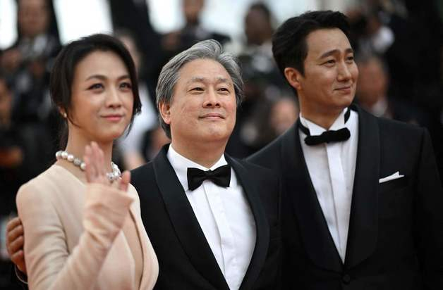 영화 '헤어질 결심'의 박찬욱 감독(가운데)이 배우 탕웨이(왼쪽), 박해일과 23일(현지시간) 프랑스 칸 국제영화제에서 기념촬영 하고 있다. /AFP=뉴스1  