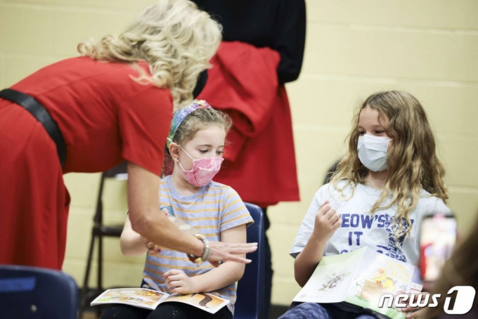 (매클레인 AFP=뉴스1) 우동명 기자 = 조 바이든 미국 대통령의 부인 질 바이든 여사가 8일(현지시간) 버지니아주 매클레인의 초등학교에 마련된 코로나19 백신 접종소에서 백신을 맞은 어린이들에게 스티커를 나눠주고 있다.   (C) AFP=뉴스1  