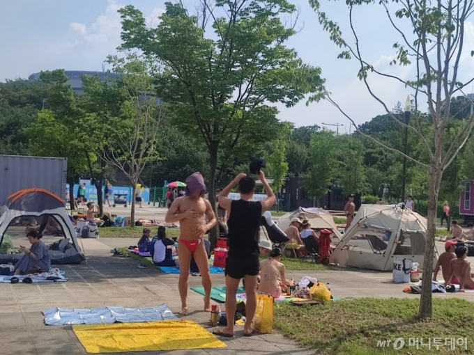 3일 오후 서울 영등포구 여의도 한강수영장에서 방문객들이 태닝을 즐기고 있다. /사진=정세진 기자
