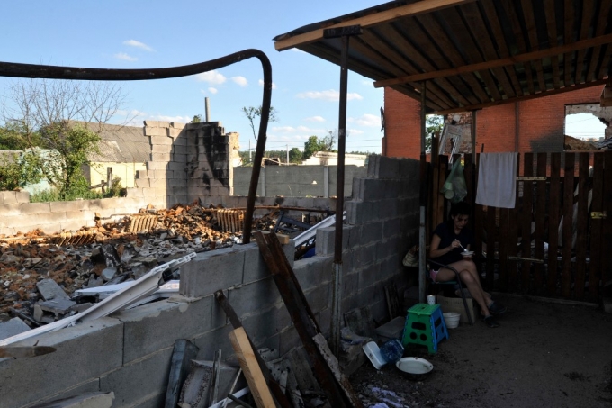28일(현지시간) 우크라이나 수도 키이우 인근 마을의 한 주민이 러시아군의 미사일 공격으로 무너진 집에서 식사를 하고 있다. /AFPBBNews=뉴스1