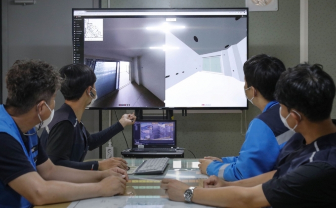 DL이앤씨 직원들이 AI 기반의 컴퓨터 비전 기술과 360도 카메라를 활용한 현장관리 솔루션인 '디비전'을 통해 시공 품질 관리를 진행하고 있다. /사진=DL이앤씨