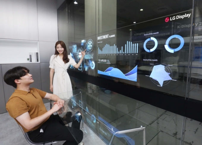 10일 서울 코엑스에서 열린 'K-디스플레이 2022'에서 LG디스플레이 모델이 '회의실용 투명 OLED 솔루션(모델명: E 크리스탈)'을 사용하고 있다./사진제공=LG디스플레이
