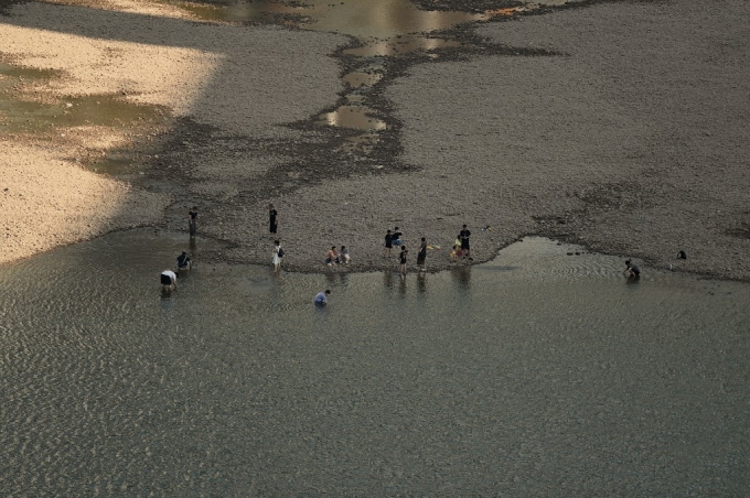 24일(현지시간) 중국 남서부 충칭시에서 양쯔강 지류인 자링강의 마른 강바닥 주변에 사람들이 서 있다./AFPBBNews=뉴스1