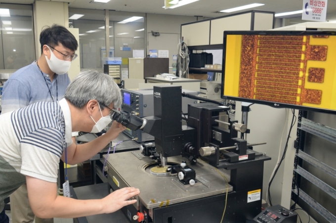  한국전자통신연구원(ETRI) 연구진이 광학현미경을 통해 S대역 300W 질화갈륨(GaN) 전력소자를 분석하는 모습. / 사진제공=한국전자통신연구원(ETRI)