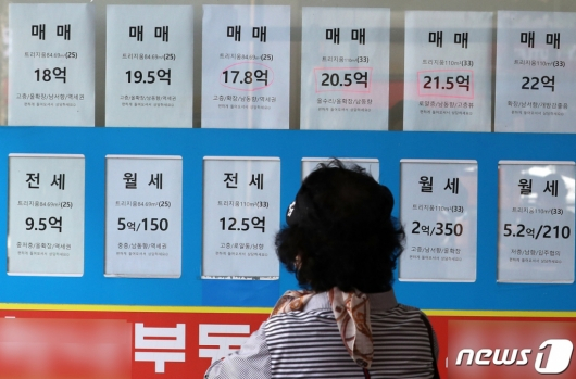 서울 송파구의 부동산중개사무소 앞에서 한 시민이 부동산 매물 가격표를 살펴보고 있다. /사진=뉴스1