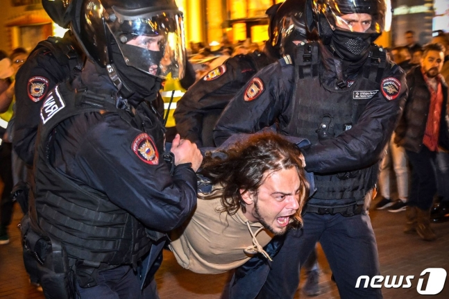 러시아가 지난 21일 군 동원령을 발동한 가운데 반대 시위 현장에서 한 남성이 체포되고 있다. / ⓒ AFP=뉴스1  