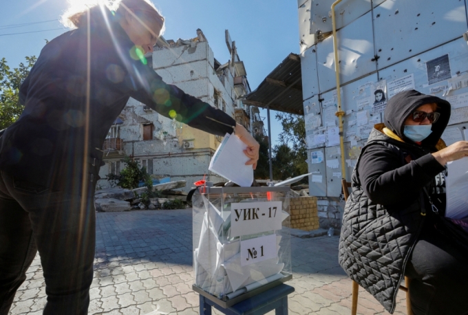 25일(현지시간) 우크라이나 마리우폴의 지역 주민이 투명 투표함에 러시아 영토 합병 찬반 주민투표 용지를 넣고 있다./로이터=뉴스1