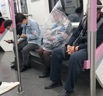 지난달 31일 중국 후베이성 우한시 지하철에서 한 여성이 큰 비닐봉지로 자신의 상체를 전부 감싼 채 바나나를 먹었다./사진=웨이보
