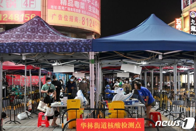 9일 중국 광둥성 광저우의 임시 진료소에서 주민들이 코로나19 검사를 받기 위해 줄을 서고 있다. /로이터=뉴스1