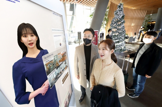모델이 노보텔 앰배서더 서울 동대문 호텔＆레지던스 1층 로비에 설치된 ‘AI 컨시어지’ 앞에서 호텔 서비스 안내를 받는 모습. /사진=KT