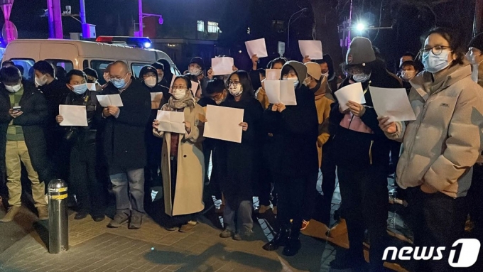지난 11월 27일(현지시간) 중국 베이징에서 정부의 고강도 제로 코로나19 봉쇄 정책에 항의하는 시위가 발생한 가운데, 참가자들이 백지를 들며 항의하고 있다./사진=뉴스1 