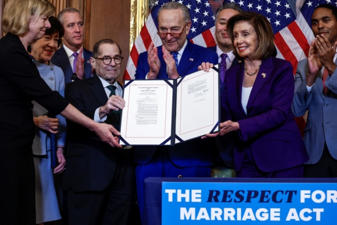 U.S. House Speaker Nancy Pelosi (D-CA) and fellow members of Congress hold &quot;The Respect for Marriage Act&quot; during a bill enrolment ceremony on Capitol Hill, in Washington, U.S., December 8, 2022. REUTERS/Evelyn Hockstein /==1