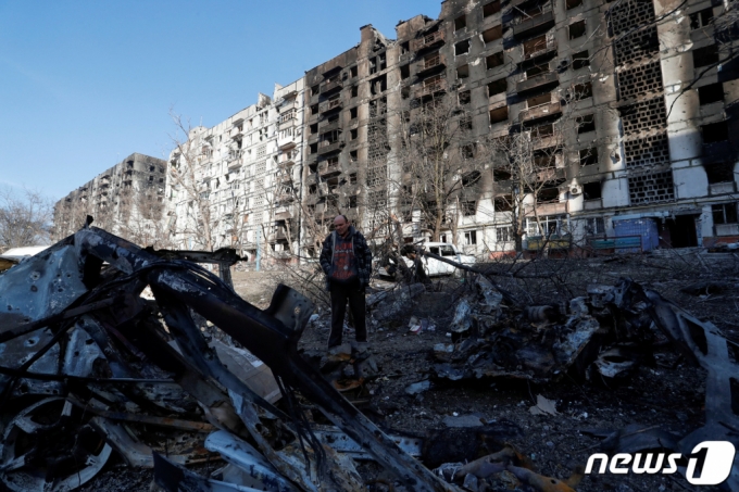 우크라이나 남부 항구도시 마리우폴에서 주민이 러시아 침공으로 파괴된 아파트의 잔해를 망연자실한 표정으로 바라보고 있다. /로이터=뉴스1