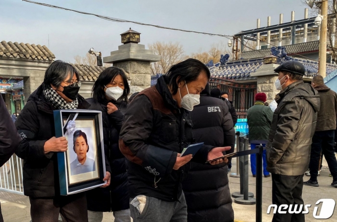 (베이징 AFP=뉴스1) 최종일 기자 = 20일 중국 베이징에 있는 한 화장터에서 가족과 친척들이 영정을 안고 있다.   ⓒ AFP=뉴스1  Copyright (C) 뉴스1. All rights reserved. 무단 전재 및 재배포 금지.