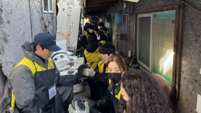 방문요양 서비스 기업 케어링의 임직원들이 서울 강남구 구룡마을에서 연탄배달 봉사활동을 하고 있다. /사진=케어링 
