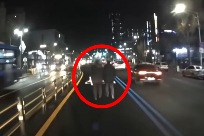 2022년 12월 25일 저녁 술에 취한 상태로 서울시 서대문구의 한 버스정용차로에서 손 잡고 걷던 두 남성의 모습 / 사진=유튜브 채널 '한문철TV' 캡처