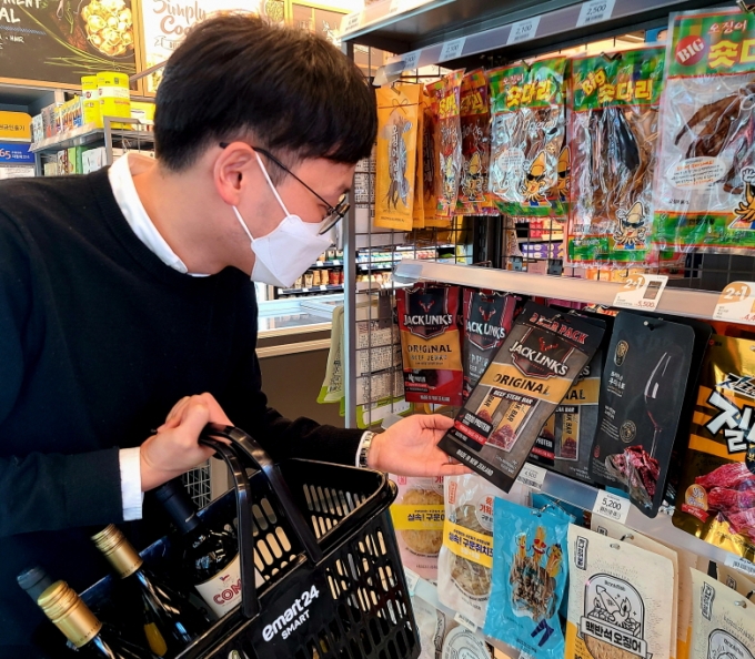 성수동에 위치한 이마트24 매장에서 고객이 '잭링크스' 소고기 육포 상품을 살펴보고 있다/사진= 이마트24 제공