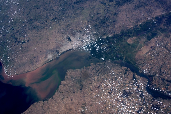 부에노스 아이레스에 있는 강이 빨간색에서 초록색 회색으로 변하는 모습. 작은 구름 점들이 땅 주변에 있다. / 사진=미국항공우주국(NASA)
