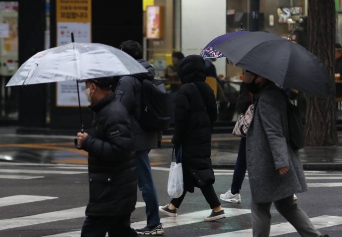 [서울=뉴시스] 고승민 기자 = 서울지역에 비가 내린 10일 서울시청 인근 도로에서 우산을 쓴 직장인들이 출근하고 있다. 2023.02.10.