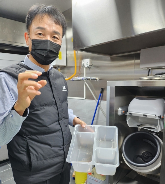 함판식 브이디컴퍼니 대표가 자회사 '식당을 구했다'에서 운영중인 '1992 덮밥&짜글이'에서 테스트중인 요리로봇을 보여주며 설명하고 있다./사진=김유경 기자