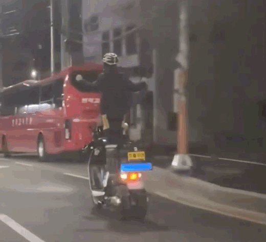 한 배달원이 주행 중인 삼륜 오토바이를 서서 타고 있다. /사진=온라인 커뮤니티