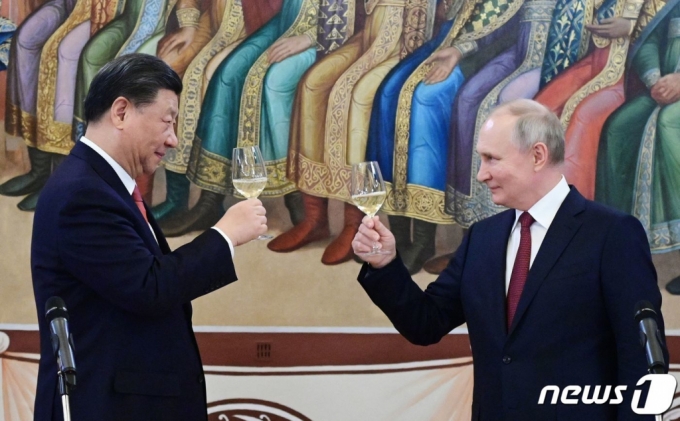시진핑 중국 국가주석과 블라디미르 푸틴 러시아 대통령이 21일(현지시간) 모스크바의 크렘린궁에서 회담을 마친 뒤 리셉션서 건배를 하고 있다.   /AFPBBNews=뉴스1
