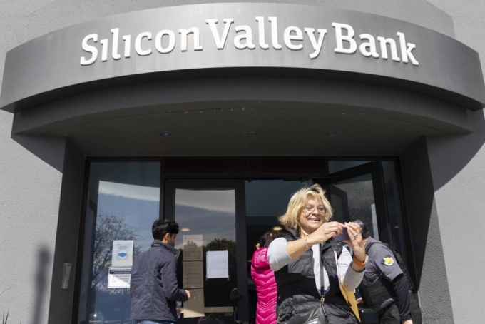 [샌타클래라=AP/뉴시스] WLSKS 13일(현지시간) 미 캘리포니아주 샌타클래라 실리콘밸리은행(SVB) 본점 앞에서 대기하다가 입장하게 된 여성이 셀카를 찍고 있다. 예금주들은 돈을 찾기 위해 은행 밖에서 줄을 서서 대기했으며 연방정부는 SVB 예금주들이 인출할 수 있는 자금을 확보하기 위해 SVB에 개입한 것으로 알려졌다. 2023.03.14.