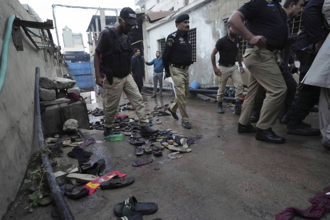  지난달 31일(현지시간) 파키스탄 카라치의 한 공장 밖 라마단 음식 무료 배급소에서 압사 사고가 발생해 경찰관들이 현장을 살피고 있다. 이 사고로 어린이 3명과 여성 8명 등 지금까지 최소 11명이 숨진 것으로 나타났다. /사진=뉴시스(AP)