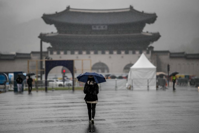 [서울=뉴시스] 정병혁 기자 = 비가 내린 5일 오후 서울 종로구 광화문광장에서 한 시민이 우산을 쓴 채 이동하고 있다. 2023.04.05.