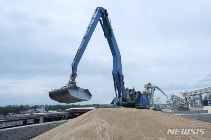 지난달 26일(현지시간) 우크라이나 오데사주 이즈마일의 곡물 항구에서 작업자들이 중장비로 화물선에 곡물을 선적하고 있다. /사진=AP/뉴시스