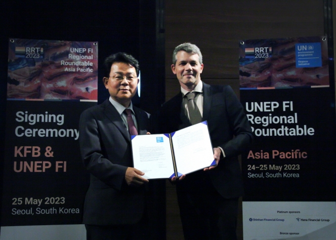 김광수 은행연합회 회장이 25일 행사에서 에릭 어셔 UNEP FI 대표와 지원기관 가입을 위한 서명식을 진행하고 있다./사진=은행연합회