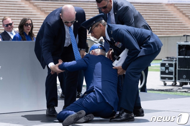 조 바이든 미국 대통령이 1일(현지시간) 콜로라도주에 있는 공군사관학교 졸업식 연설 후 넘어져서 부축을 받고 있다./사진= ⓒ AFP=뉴스1