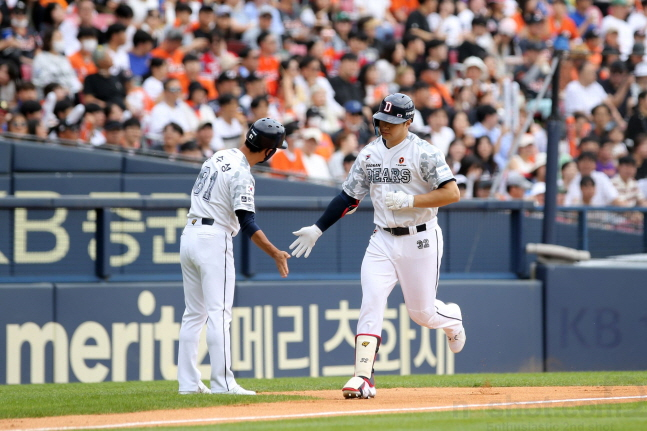  김재환(오른쪽)이 홈런을 날린 뒤 3루 베이스를 돌아 정수성 코치와 하이파이브를 하고 있다. /사진=두산 베어스