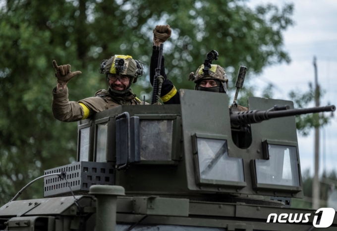  5일 (현지시간) 러시아 군의 포격 중 우크라이나 하르키우에서 병사가 무장 차량을 타고 이동을 하고 있다. /로이터=뉴스1
