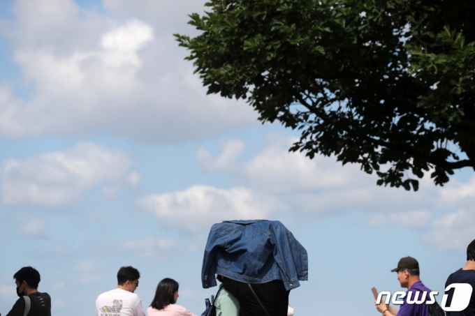 지난달 29일 서울 중구 남산에서 한 시민이 옷으로 햇빛을 가리고 있다./사진=뉴스1