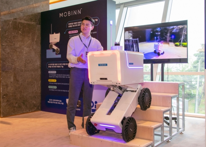 라스트마일 배송 로봇 전문 기업 모빈 관계자가 배송 로봇에 대해 설명하는 모습. /사진제공=현대차그룹.